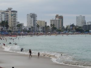 curved bay with a heavily populated beach backed with high rise white tower blocks