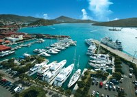 aerial view of the marina at crown bay with many large superyachts in the foreground and smaller yachts behind. 