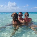 chloe the dog with her 2 owners and fellow crew members in the sea together