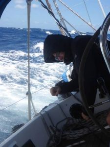 Person on the deck of yacht in wet weather gear